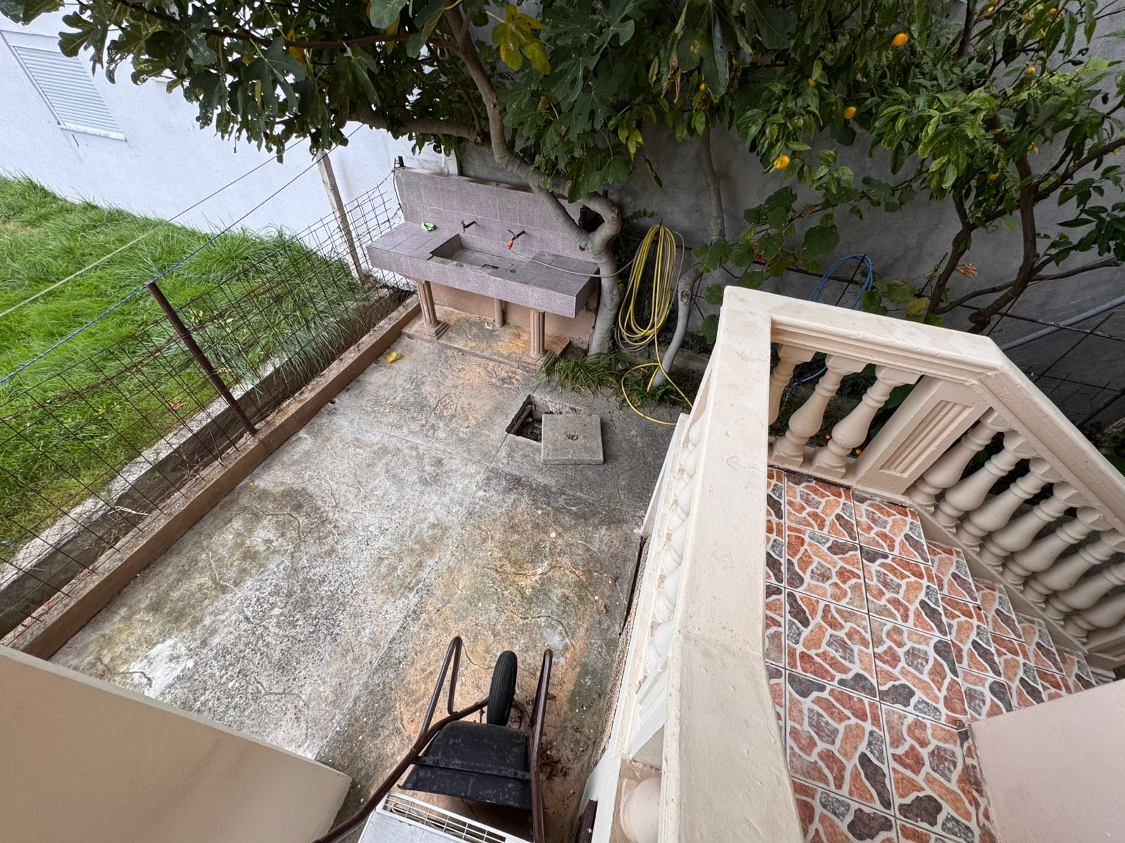 Spacious concrete backyard with tiled staircase, tree, utility sink—ideal Ulcinj investment via montenegro-listings.me by ekosphere doo.
