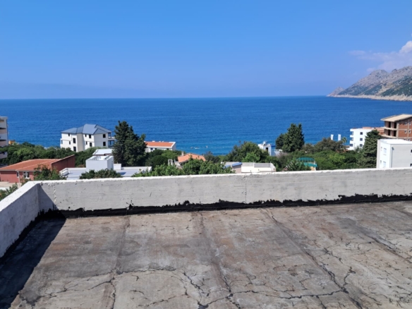 Panoramic rooftop view over Ulcinj: residential homes, lush greenery, Adriatic Sea—prime Montenegro real estate by ekosphere doo.