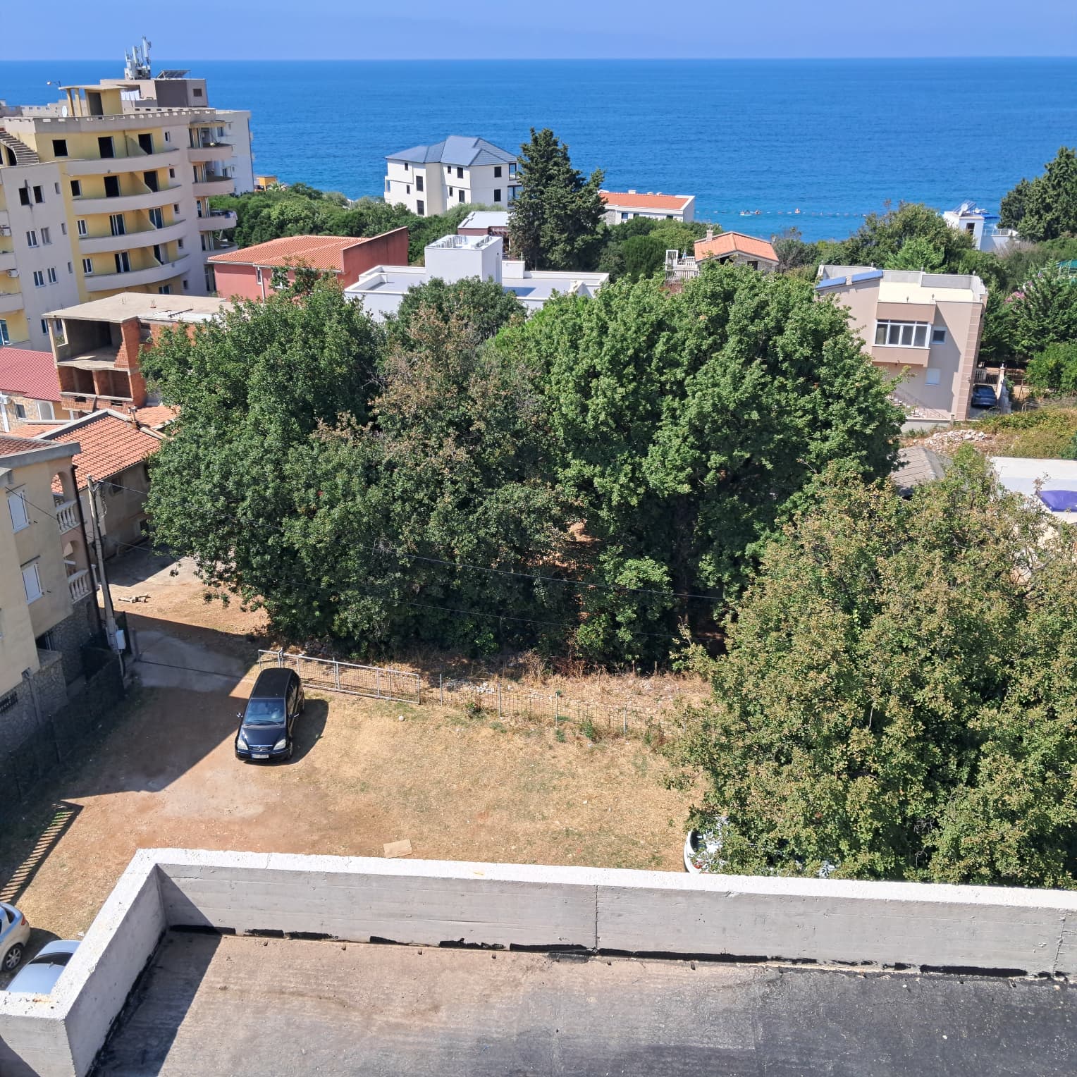 Elevated sea view in Ulcinj: greenery, residential homes, and Adriatic backdrop—prime Montenegro investment by ekosphere doo.