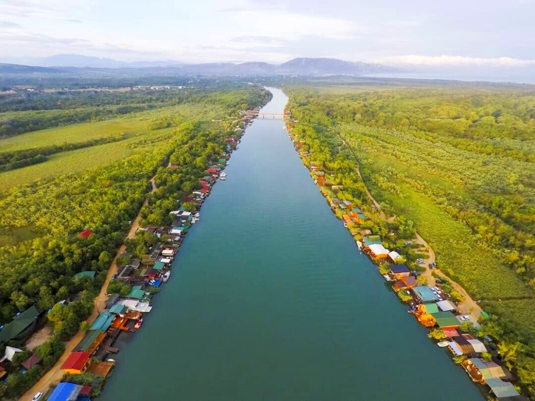 Ada Bojana: Sustainable Real Estate in Ulcinj 13 Aerial view of Ada Bojana triangle with dunes, wooden houses, and Adriatic shoreline – Montenegro Listings