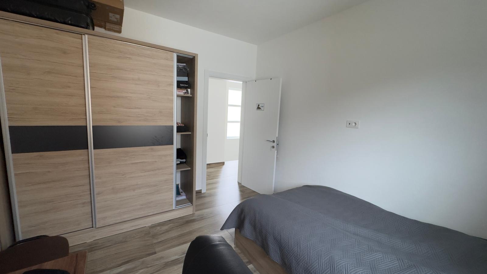 Bright, modern bedroom in Ulcinj featuring sleek storage, cozy bed, and natural light&mdash;exclusive at montenegro-listings.me by ekosphere doo.