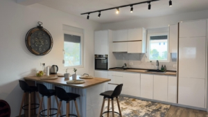 Elegant Ulcinj kitchen: bright, modern design with white cabinets, island bar, wood tops, premium oven. Exclusive at montenegro-listings.me by ekosphere doo.