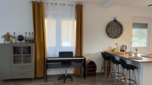 Stylish Ulcinj apartment: modern kitchen, bar stools, bright mustard curtains, ideal investment. Listed by montenegro-listings.me/Ekosphere DOO.