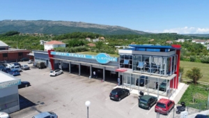 Prime commercial property in Ulcinj: modern auto service center, glass frontage, service bays, parking, mountain views—invest via montenegro-listings.me, a project of ekosphere doo.