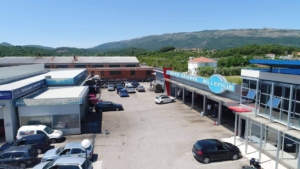 Prime commercial property in Ulcinj, Montenegro: spacious paved lot with auto shops, scenic hills—ideal investment at montenegro-listings.me.