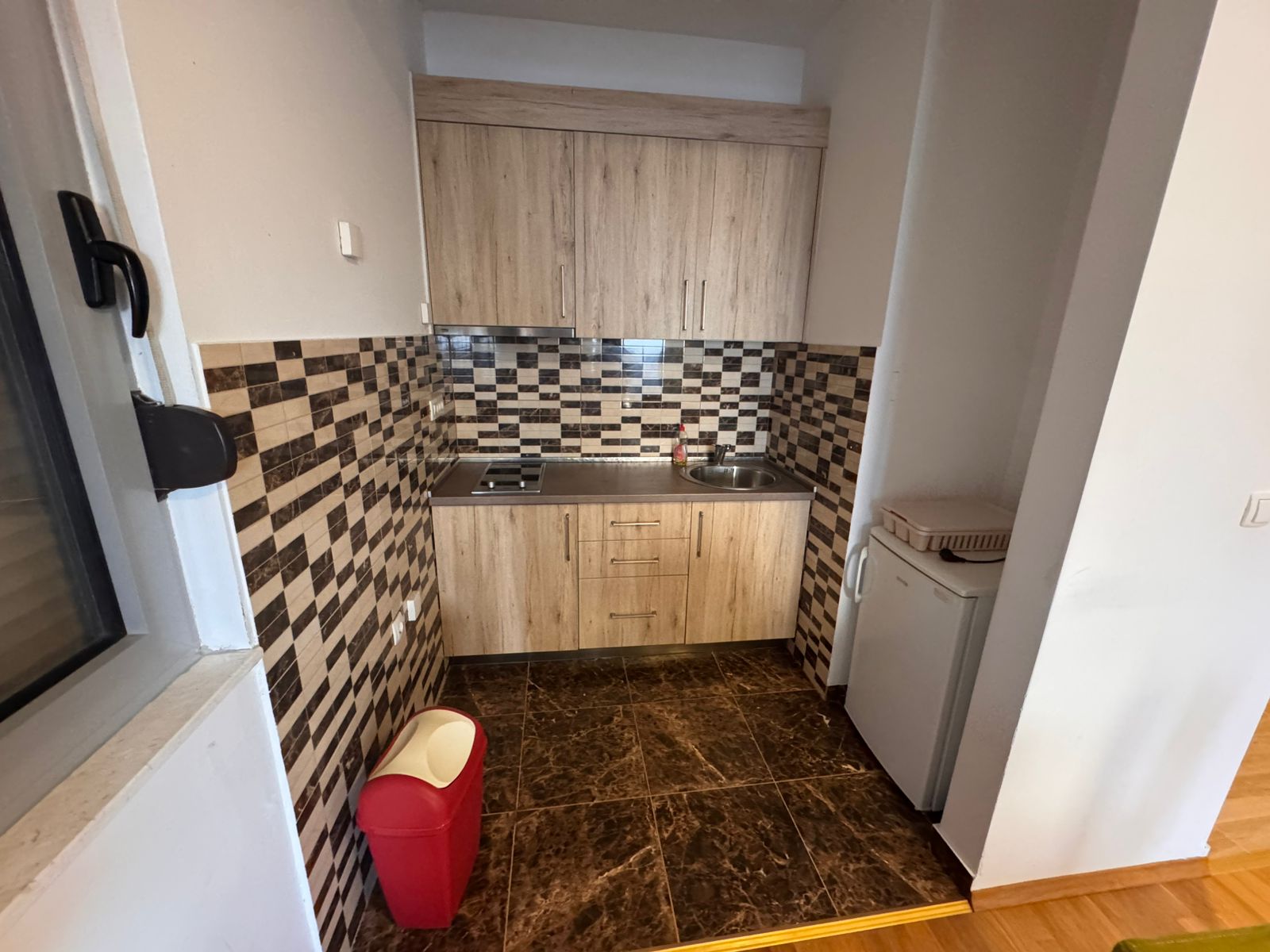 Modern kitchenette in Ulcinj with wood cabinets, premium appliances, marble floors&mdash;ideal Montenegro property investment. By ekosphere doo.