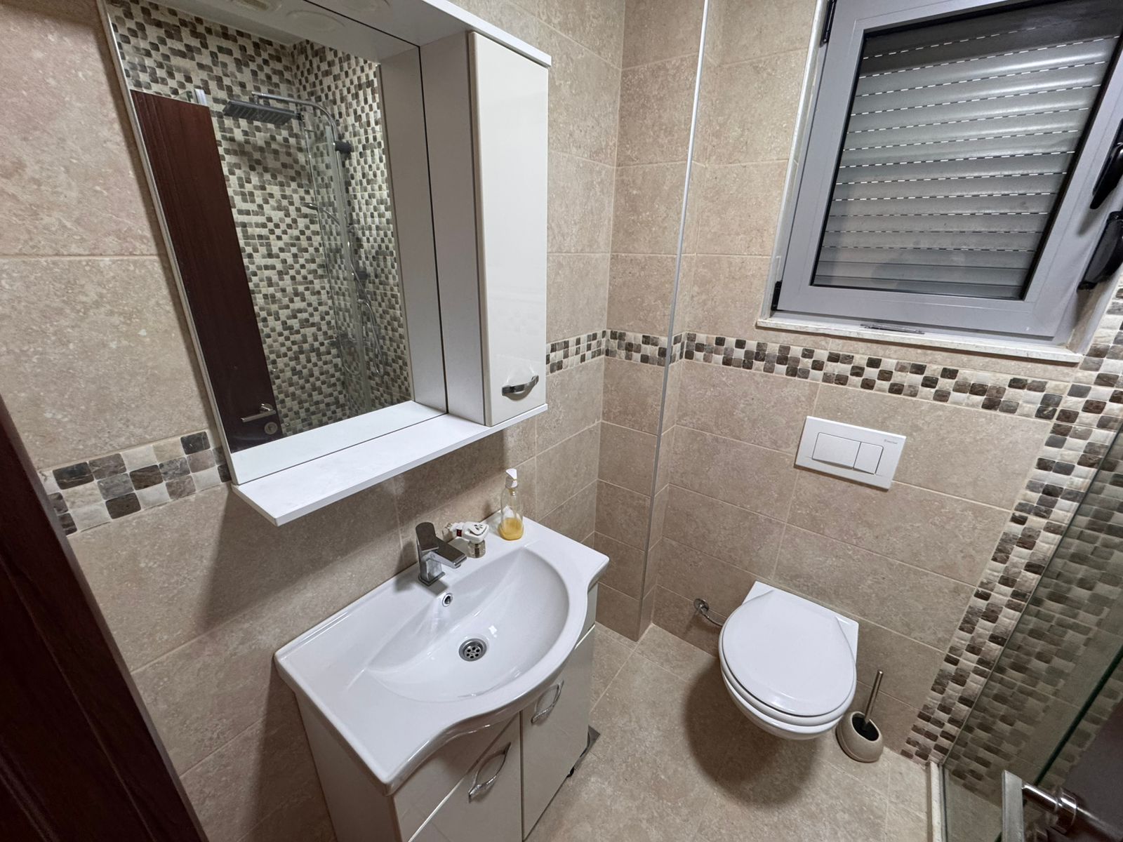 Modern bathroom in Ulcinj with beige tiles, quality fixtures, and natural light&mdash;exclusive listing by montenegro-listings.me & ekosphere doo.