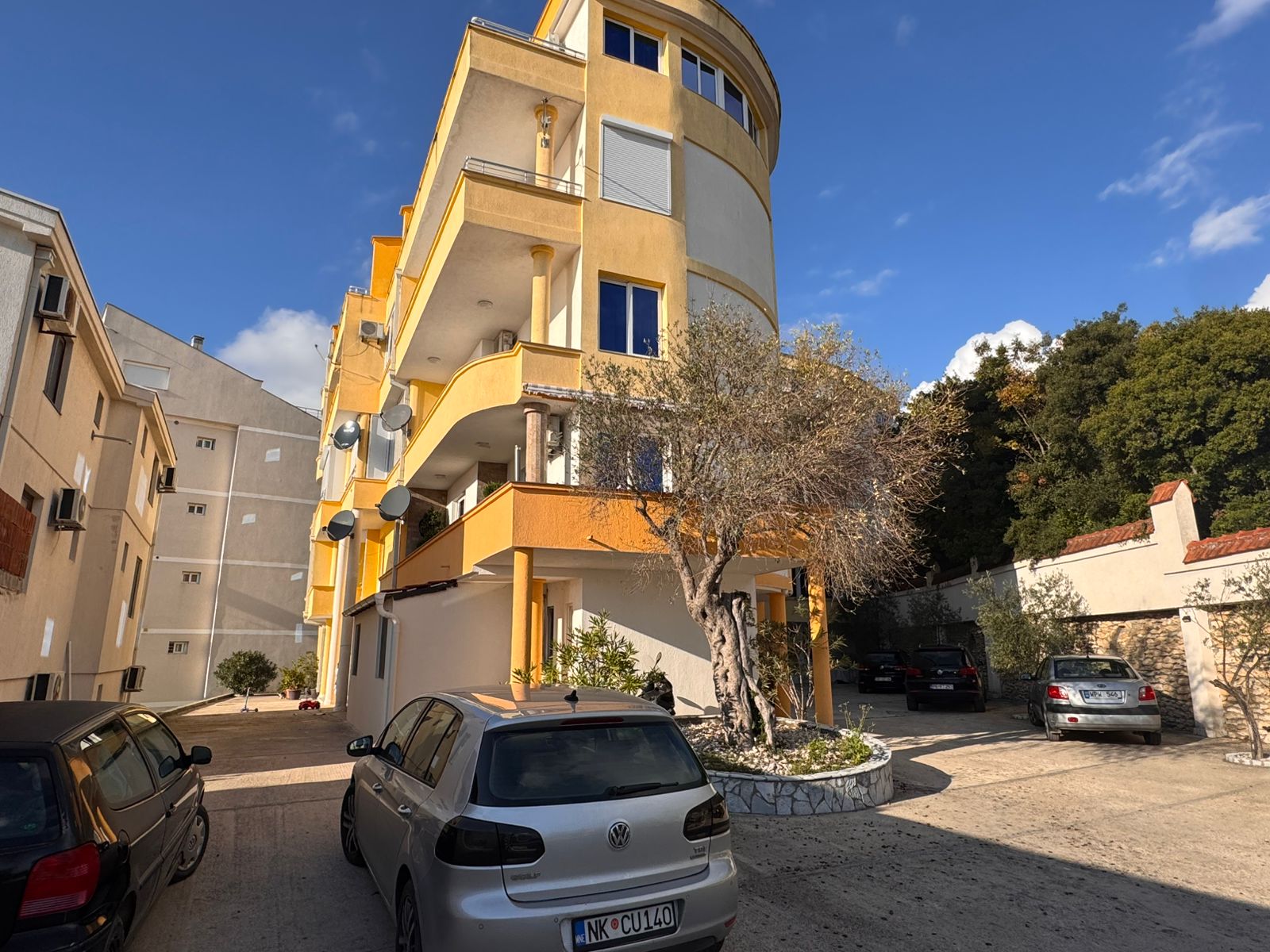 Modern three-story apartment building in Ulcinj, Montenegro&mdash;ideal investment with balconies, parking, and lush trees. eksosphere doo.