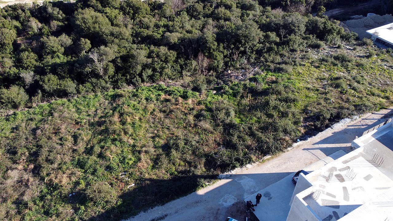 Prime Ulcinj land for investment: spacious plot near white building, dirt road access, lush greenery&mdash;exclusive at montenegro-listings.me by ekosphere doo.