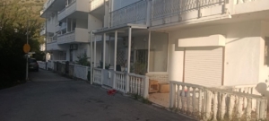 Modern white residential property in Ulcinj, Montenegro, with balconies, porch, and scenic hill views—exclusive on montenegro-listings.me.