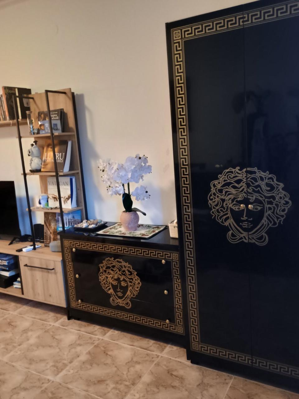 Sophisticated Ulcinj living room featuring luxury gold-accented cabinetry, bookshelf, TV; exclusive listing by montenegro-listings.me.