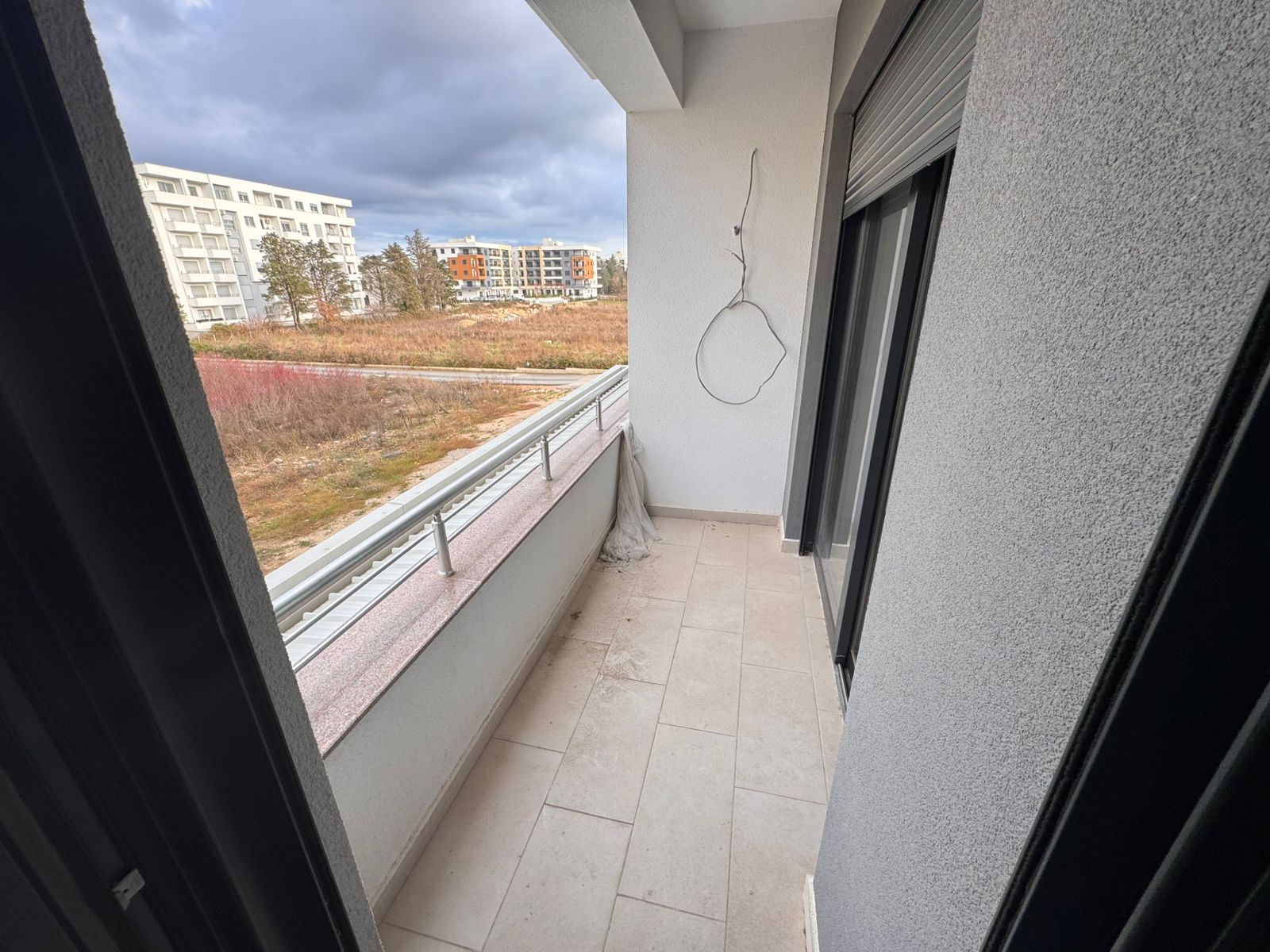 Modern Ulcinj balcony with elegant tiles, partial railing, and open views&mdash;prime Montenegro investment via montenegro-listings.me by ekosphere doo.