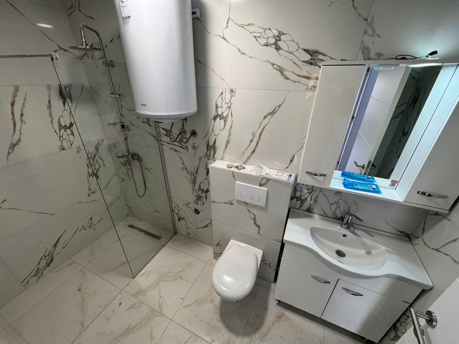 Luxurious Ulcinj bathroom with marble tiles, glass shower, modern fixtures. Prime Montenegro investment by ekosphere doo on montenegro-listings.me.