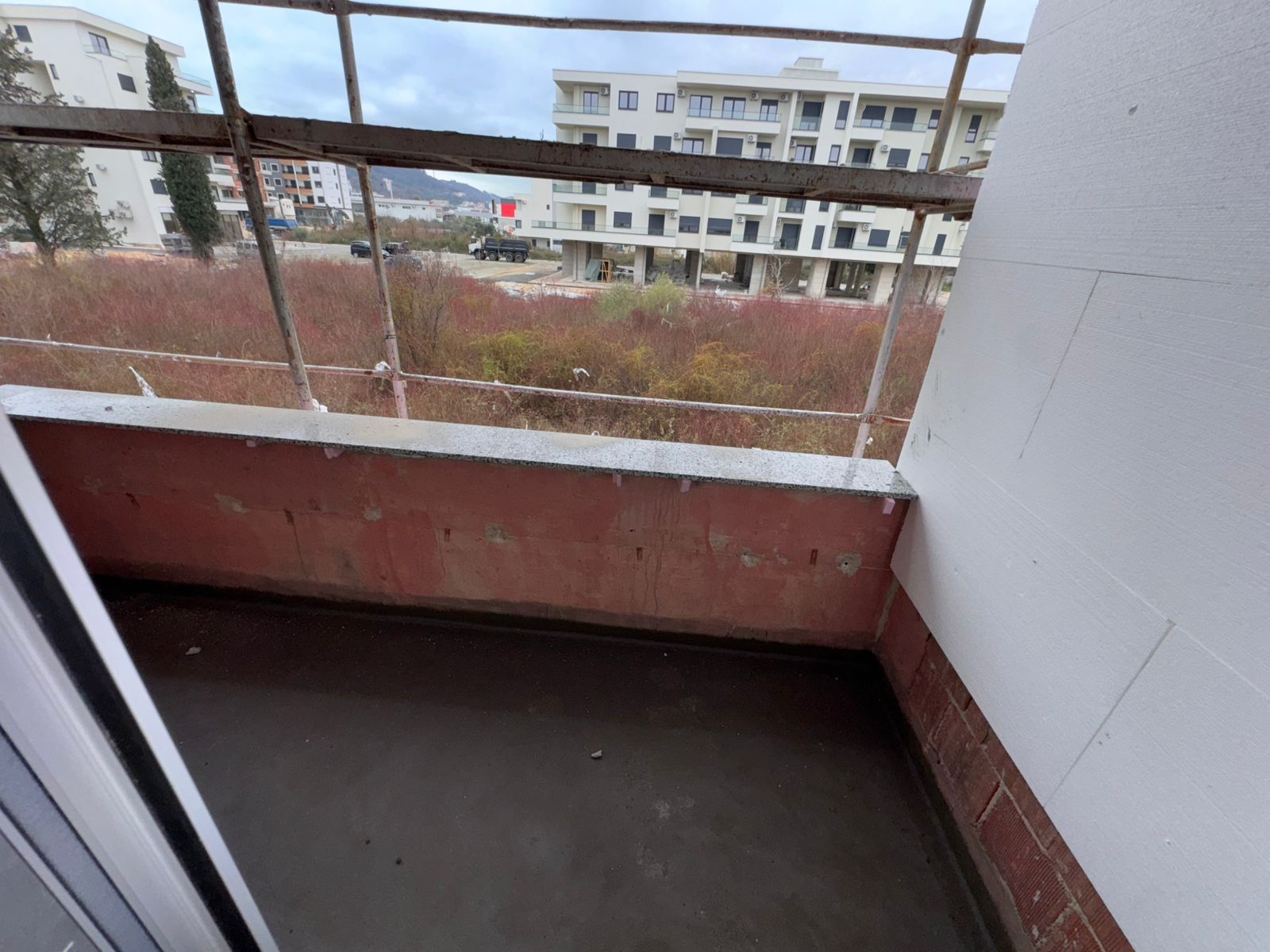 Unfinished red-brick balcony in Ulcinj with field views, near new apartments. Prime investment&mdash;see montenegro-listings.me by ekosphere doo.