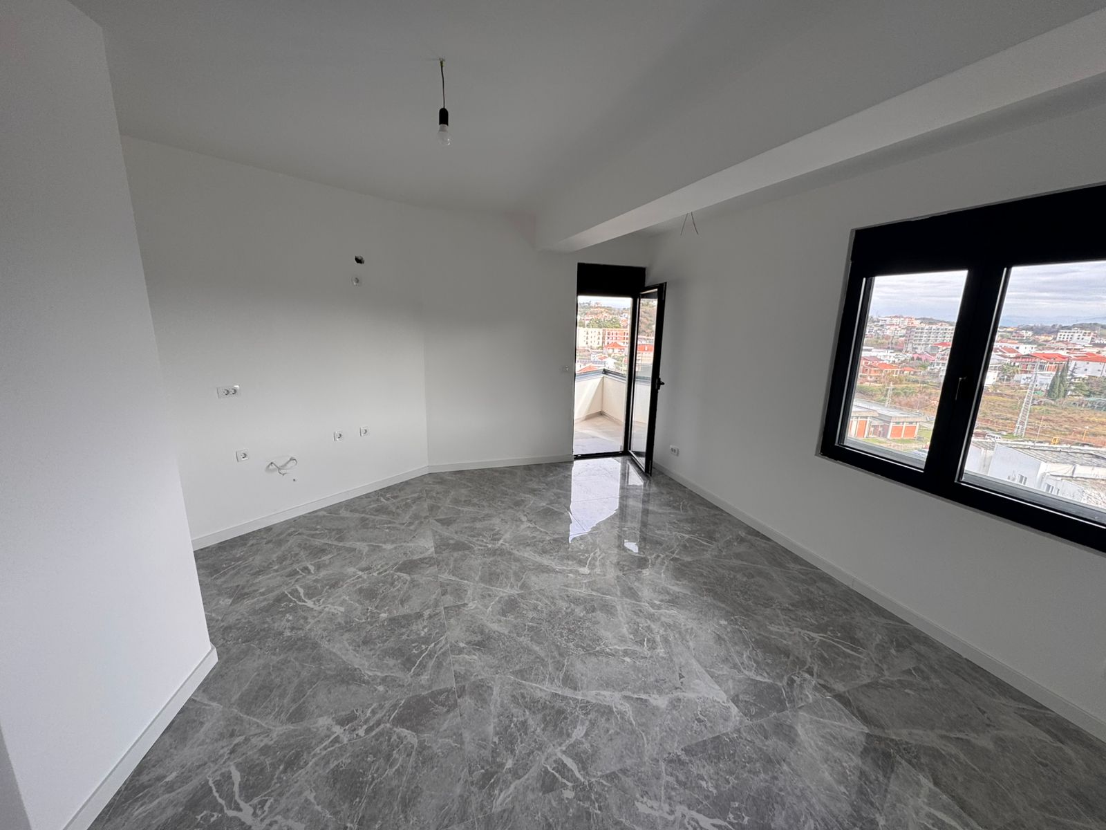 Modern unfurnished Ulcinj apartment with sleek marble floors, balcony city views; exclusive at montenegro-listings.me by ekosphere doo.