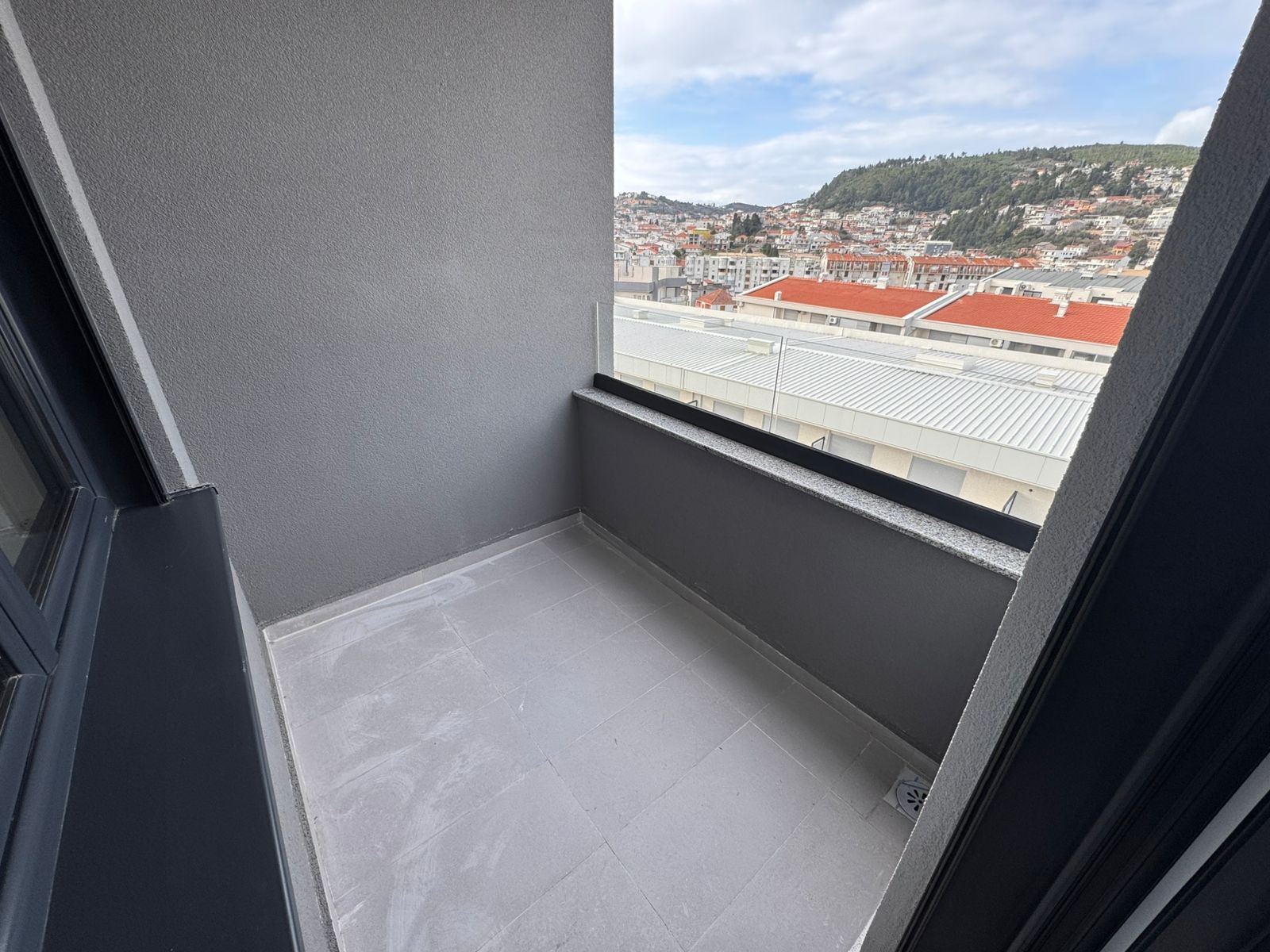 Modern balcony with gray tiles and city views of Ulcinj, ideal Montenegro investment. Exclusive on montenegro-listings.me by ekosphere doo.