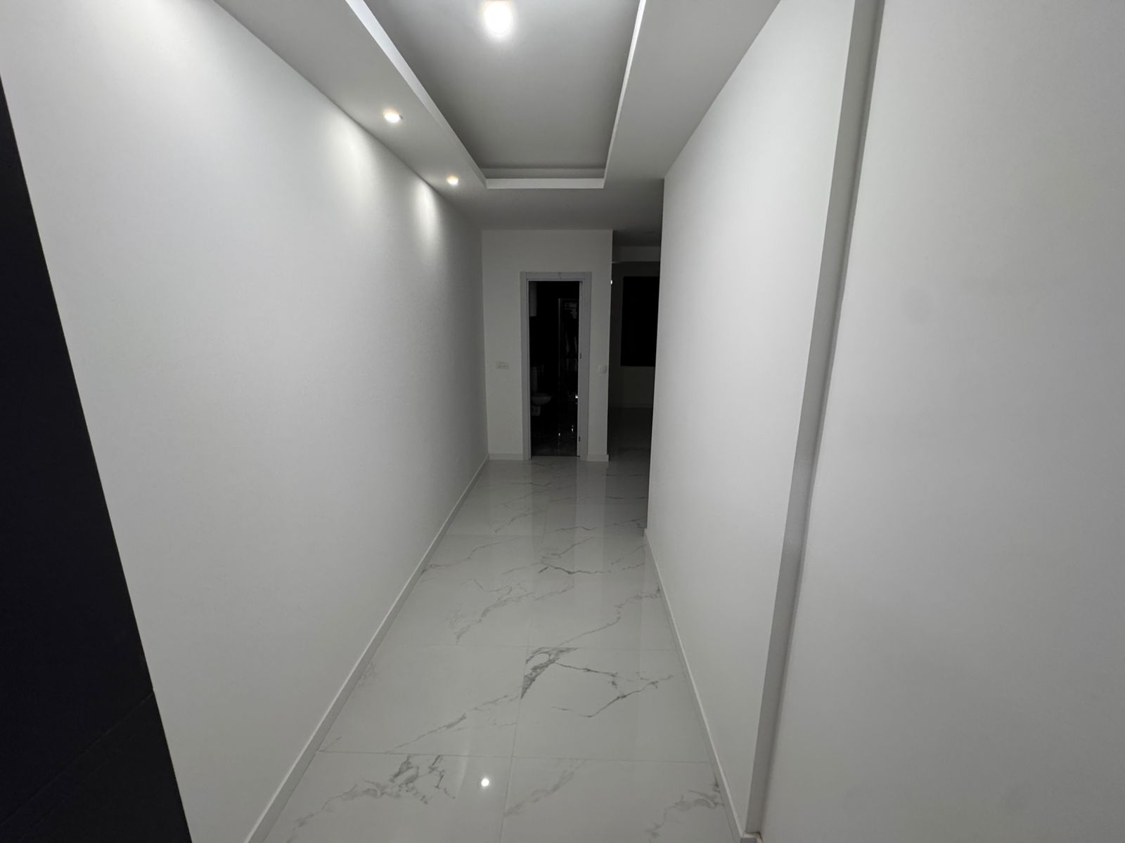 Schlichter, moderner Flur mit wei&szlig;en Marmorb&ouml;den und heller Beleuchtung - exklusive Ulcinj Anlageimmobilie bei montenegro-listings.me by ekosphere doo.