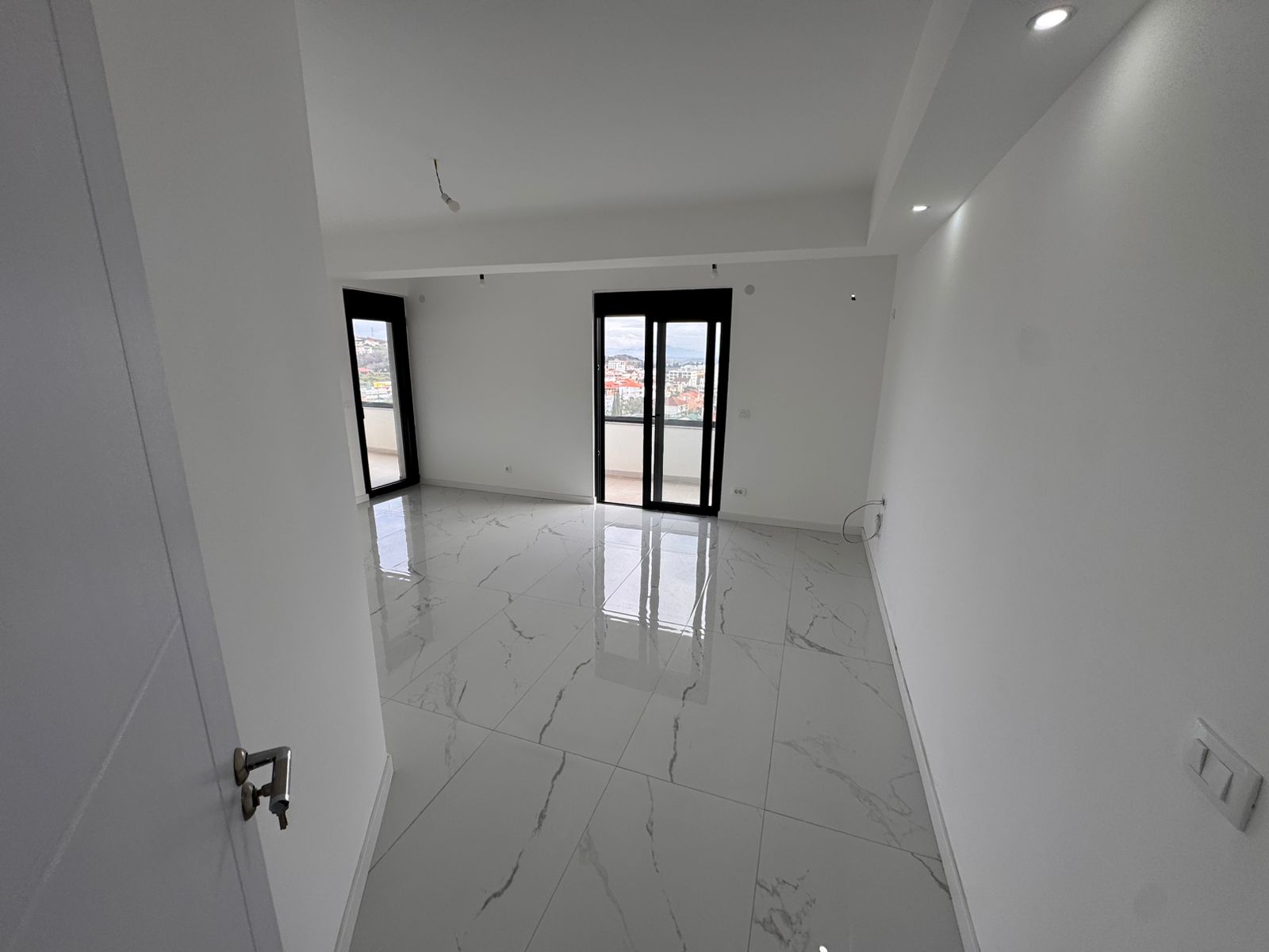 Spacious, sunlit room with glossy tiles, balcony views, and large windows—prime Ulcinj real estate by ekosphere doo on montenegro-listings.me. Spacious, sunlit room with glossy tiles, balcony views, and large windows—prime Ulcinj real estate by ekosphere doo on montenegro-listings.me.