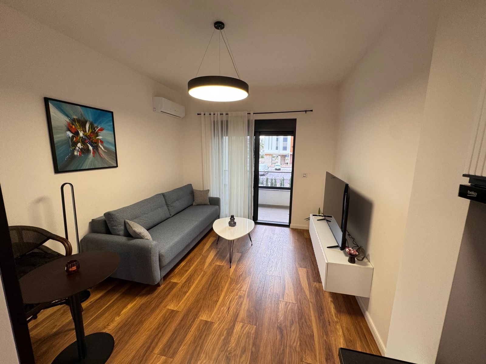 Elegante Wohnung in Ulcinj: modernes Wohnzimmer, Holzböden, stilvolles graues Sofa, Klimaanlage und hochwertige Ausstattung. Exklusiv auf montenegro-listings.me von ekosphere doo. 