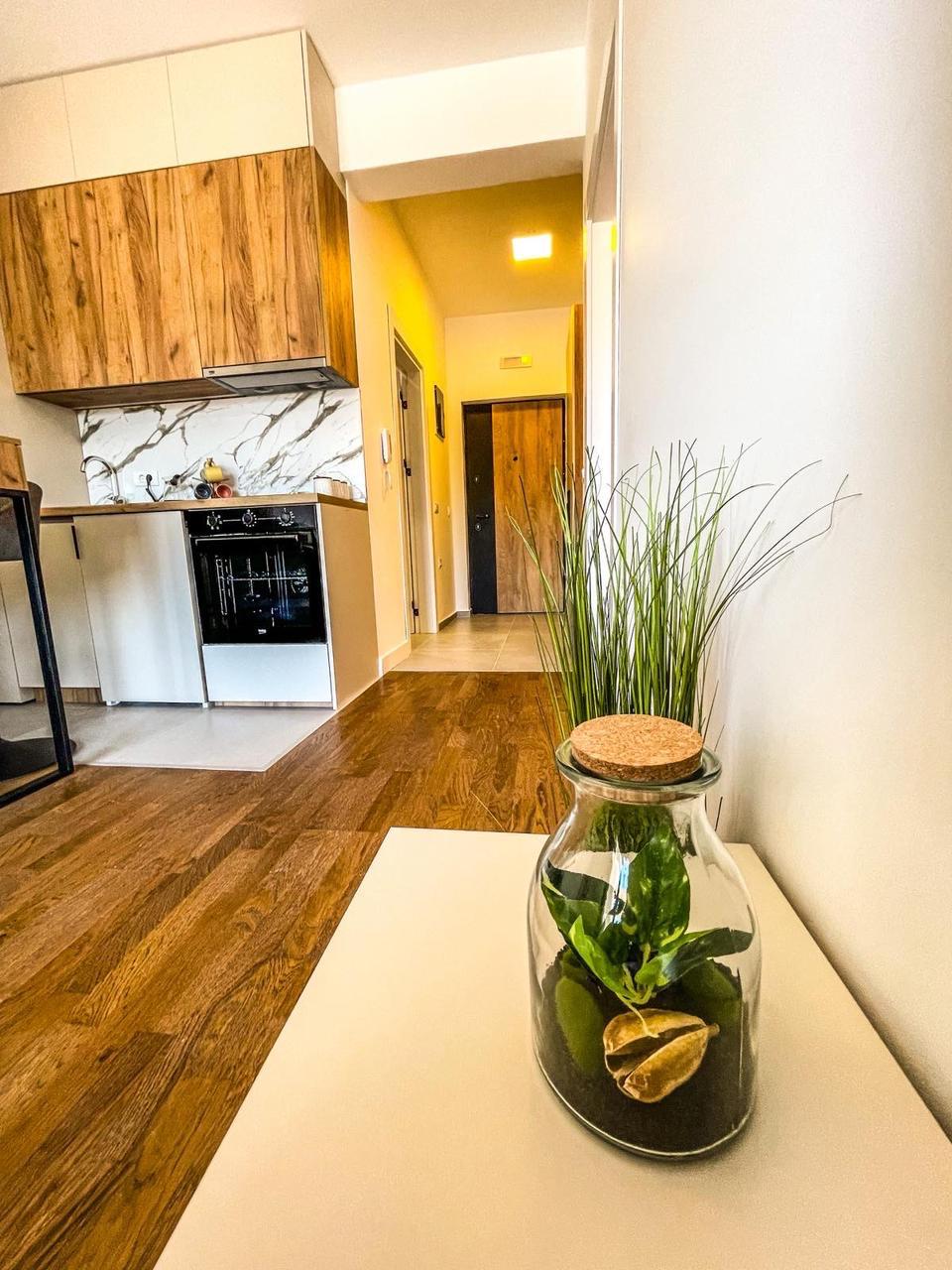 Bright Ulcinj kitchen with wooden cabinets, sleek stove, and hallway; stylish decor on white table. Exclusive at montenegro-listings.me by ekosphere doo.