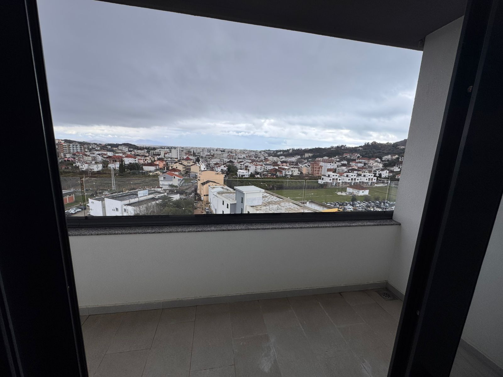 Stunning covered balcony in Ulcinj, Montenegro&mdash;tiled floors, city views, lush greenery. Invest with montenegro-listings.me by ekosphere doo.