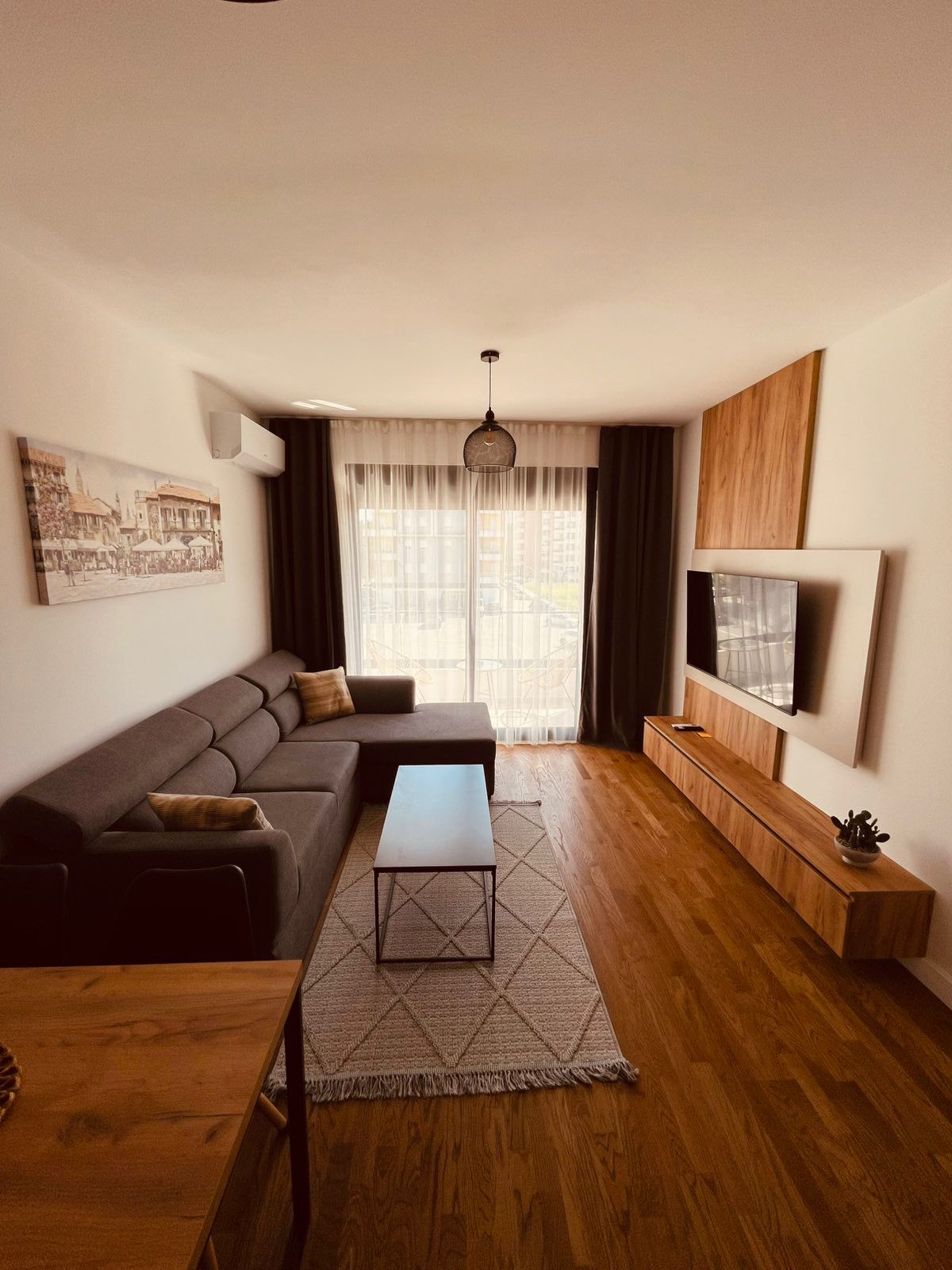 Stunning Ulcinj apartment for sale: modern living room, gray sectional, wall TV, light wood floors&mdash;exclusive at montenegro-listings.me by ekosphere doo.