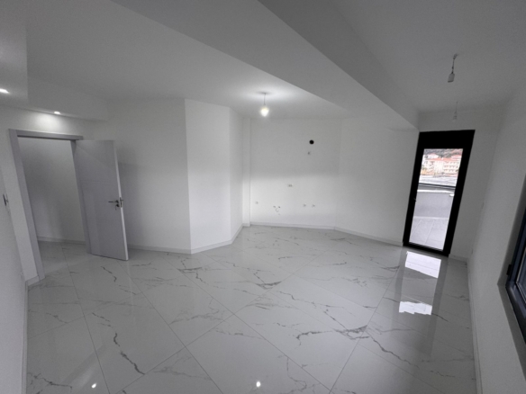 Bright, unfurnished room in Ulcinj with elegant marble-pattern tiles, white walls, balcony access&mdash;ideal investment via montenegro-listings.me.