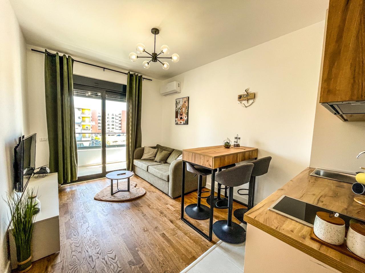 Stylish, sunlit Ulcinj apartment: modern living/kitchen, wood floors, balcony view. Invest in Montenegro-listings.me by ekosphere doo.