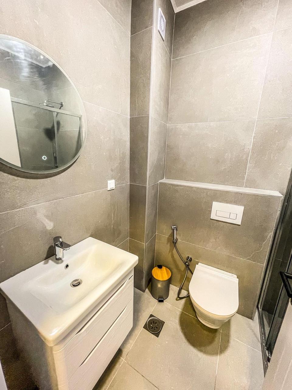 Contemporary bathroom in Ulcinj, Montenegro: gray tiles, glass shower, wall toilet&mdash;ideal for investment. Listed on montenegro-listings.me by ekosphere doo.