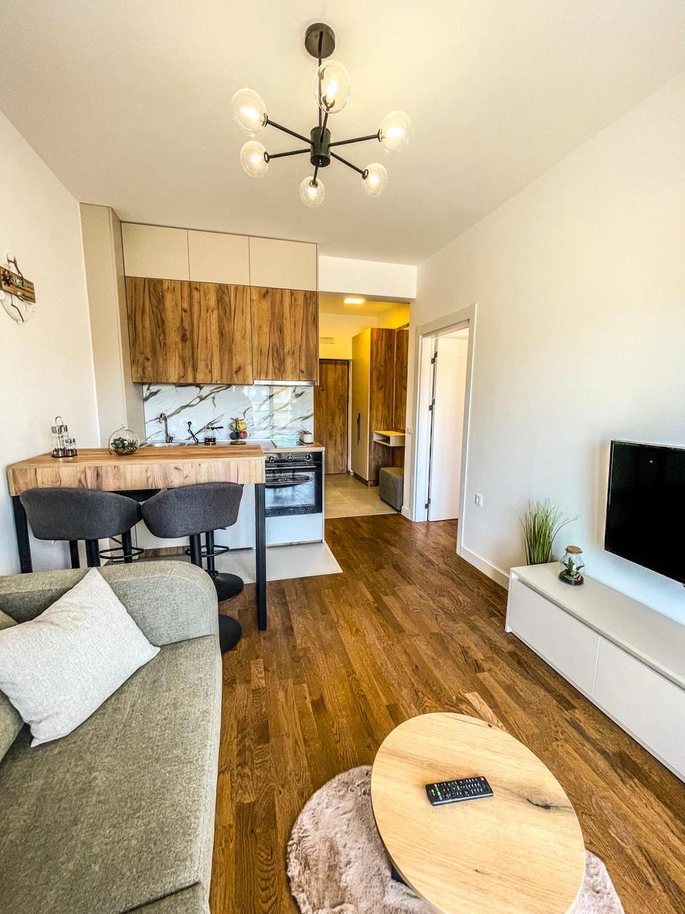 Stylish Ulcinj apartment: wood floors, gray sofa, open kitchen, ideal investment. Exclusive on montenegro-listings.me by ekosphere doo.