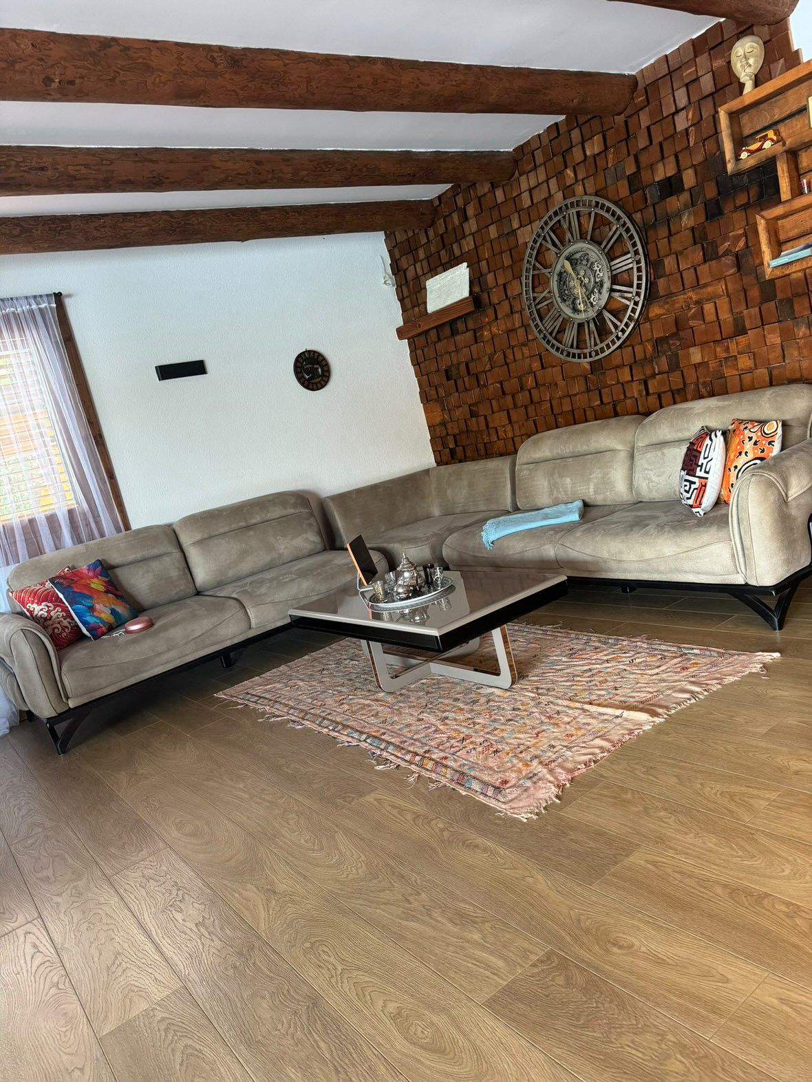 Elegant Ulcinj living room: L-shaped gray sofa, accent cushions, luxe wood finishes&mdash;prime Montenegro investment. eksosphere doo project.