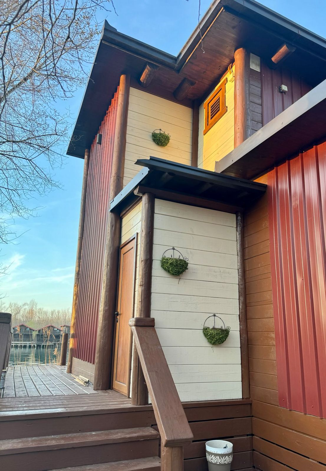 Charming two-story Ulcinj home with stylish siding, large deck, and planters&mdash;ideal Montenegro real estate via ekosphere doo.