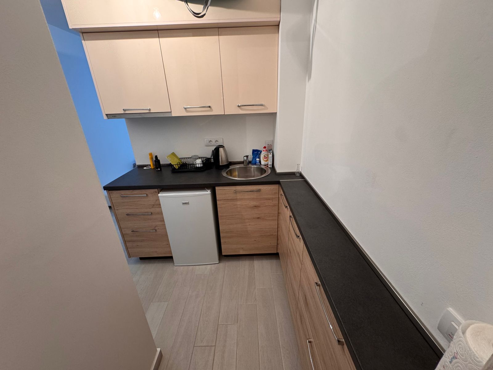 Modern compact kitchen in Ulcinj with light wood cabinetry, quality finishes&mdash;ideal Montenegro investment. Montenegro-listings.me by ekosphere doo.