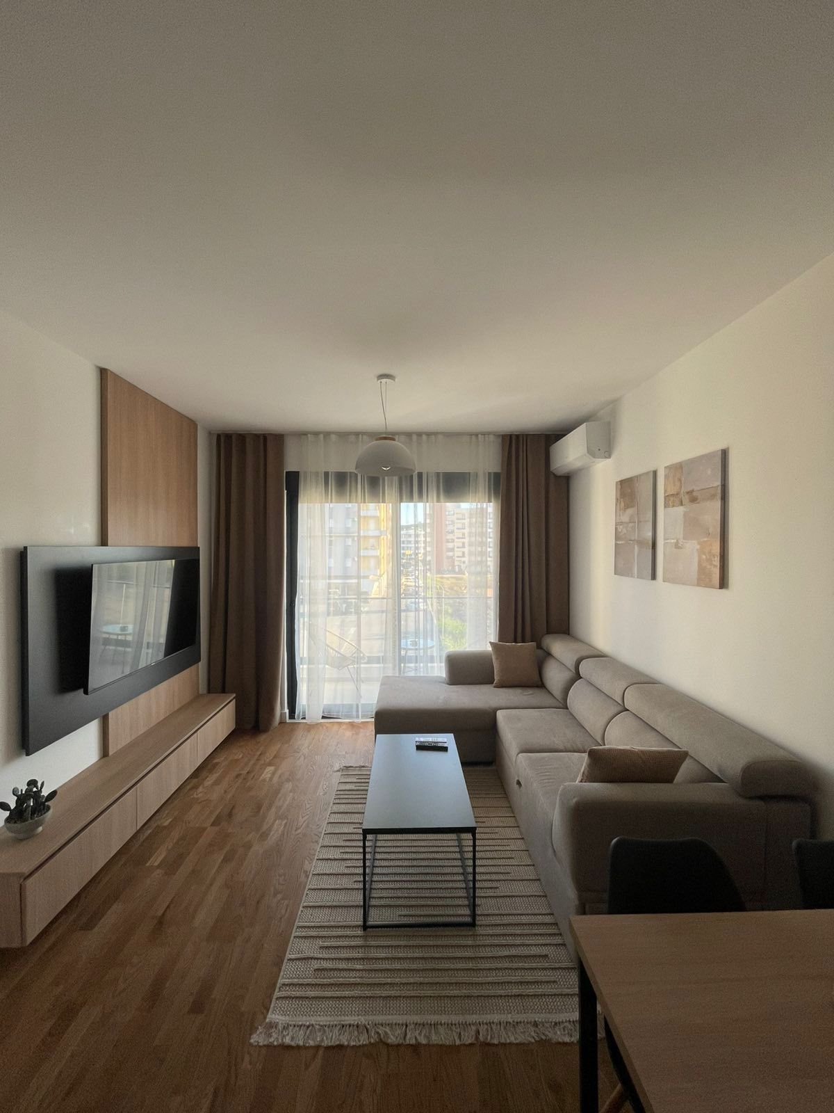 Elegant Ulcinj apartment: modern living, beige sectional, bright window, wood floors. Exclusive on montenegro-listings.me by ekosphere doo.