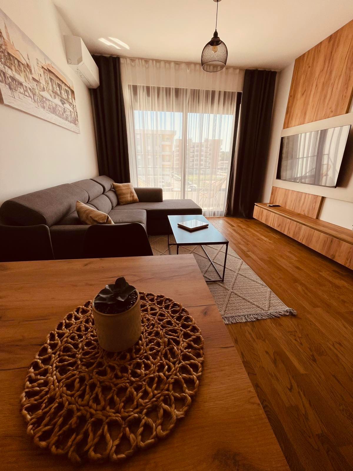Stylish Ulcinj apartment: modern living area, gray sectional, smart TV, bright windows&mdash;prime real estate by montenegro-listings.me.