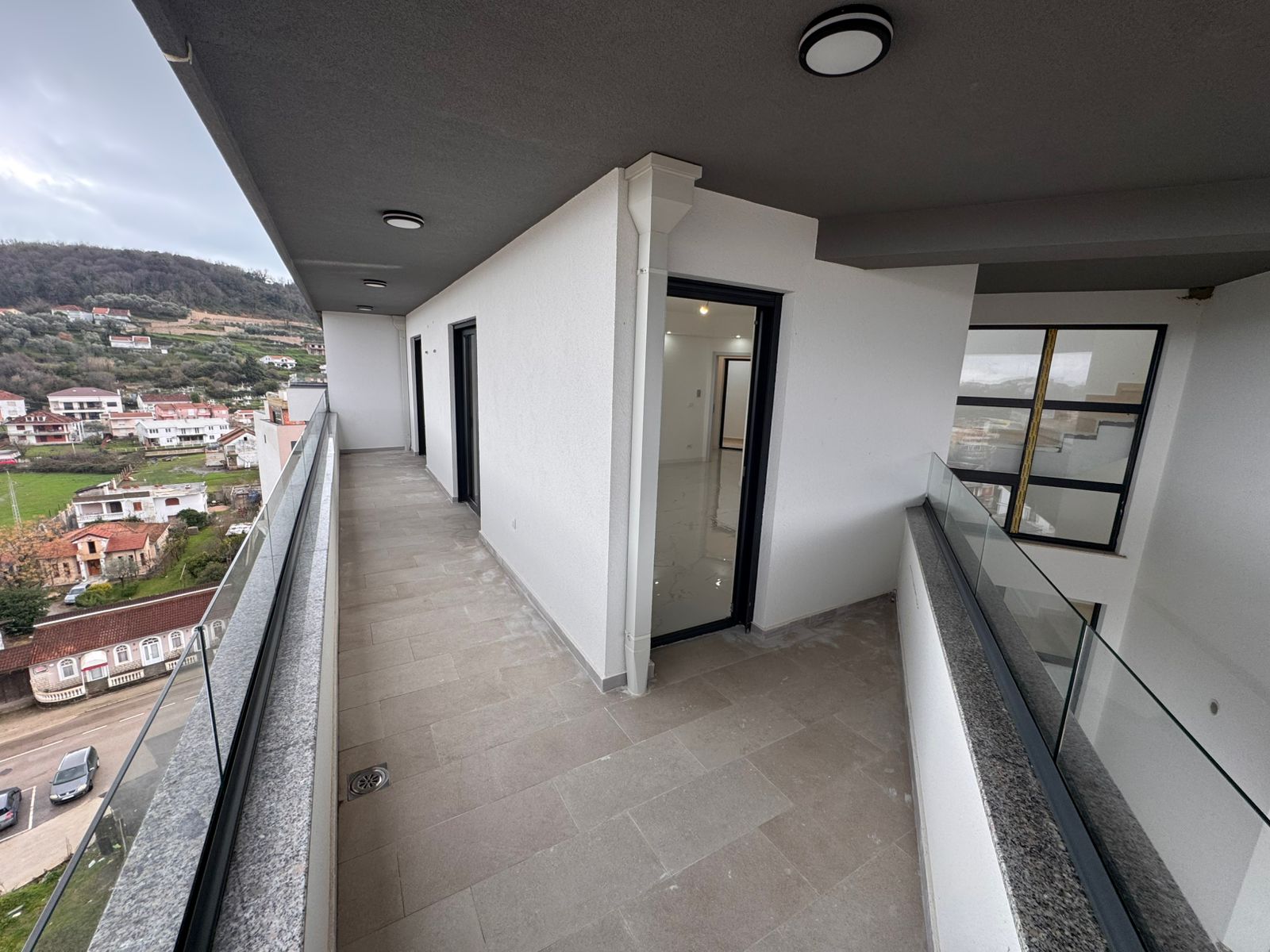 Spacious modern balcony with glass railings, open doors, and panoramic rural Ulcinj views&mdash;prime property by ekosphere doo.