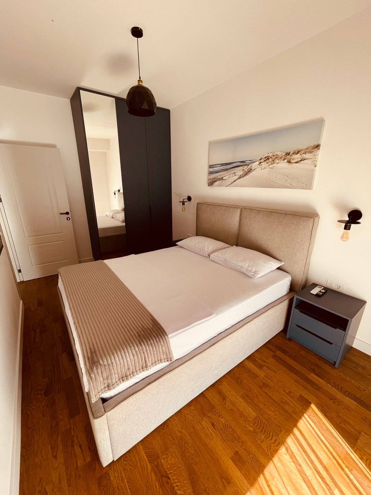 Modern Ulcinj bedroom for sale: white bedding, mirrored closet, wood floors. Invest with montenegro-listings.me by ekosphere doo.