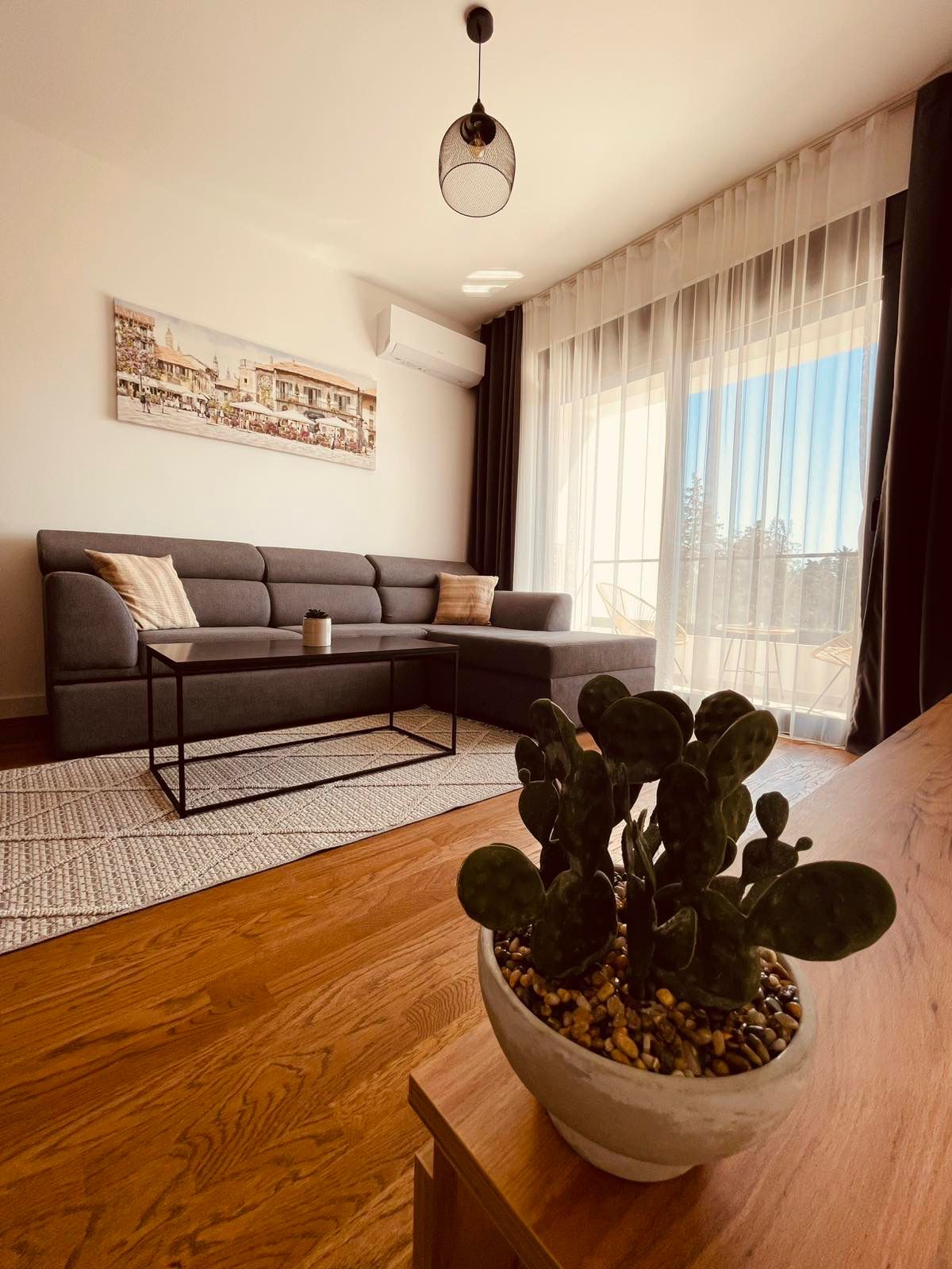 Elegant Ulcinj apartment for sale: modern living room, gray sectional, sunlit windows; prime Montenegro property at montenegro-listings.me. Elegant Ulcinj apartment for sale: modern living room, gray sectional, sunlit windows; prime Montenegro property at montenegro-listings.me.