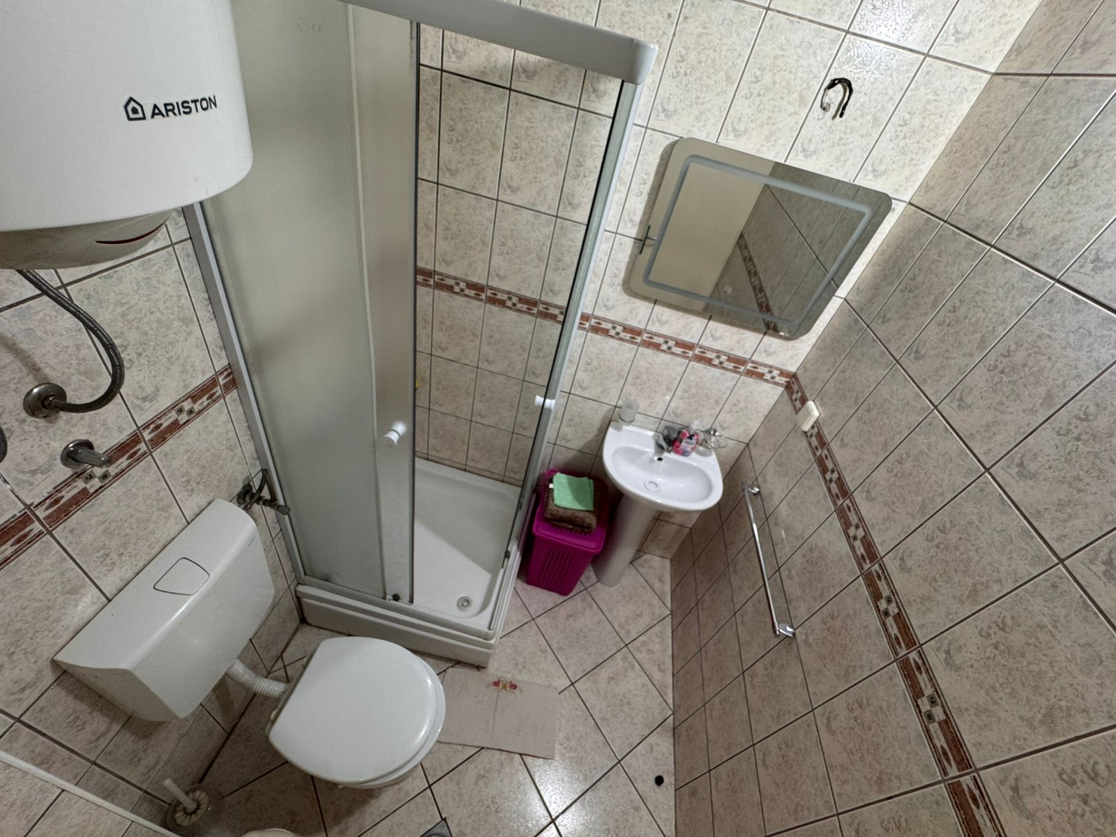 Modern tiled bathroom in Ulcinj with corner shower, compact design, ideal Montenegro investment. Listed by ekosphere doo—montenegro-listings.me.