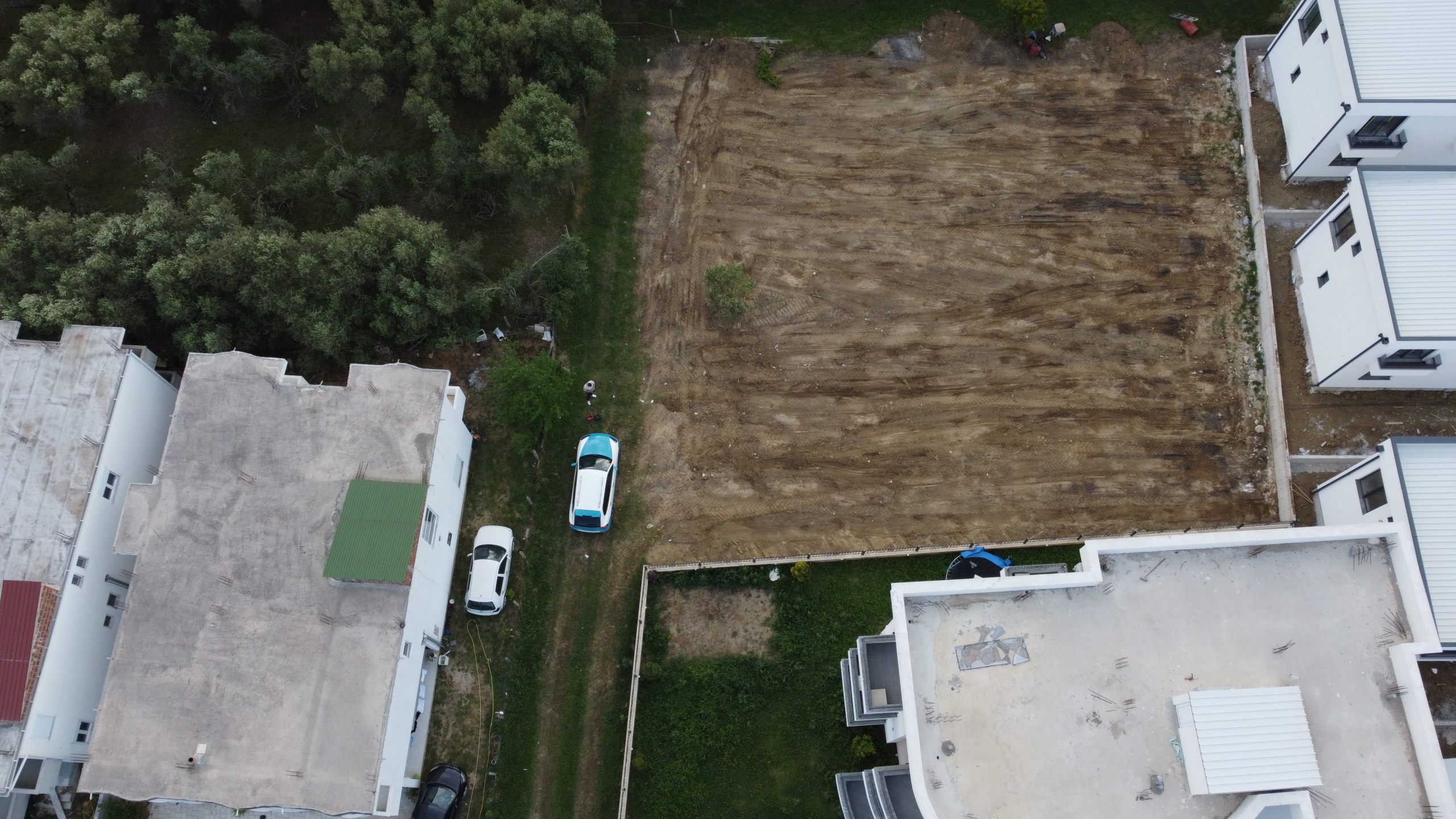 Prime investment opportunity: Cleared land in Ulcinj, Montenegro, near modern homes, greenery, and parking. eksphere doo project.