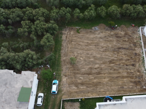 Prime investment opportunity: cleared land between two white buildings in Ulcinj, Montenegro—ideal for new development. Montenegro-listings.me by ekosphere doo.
