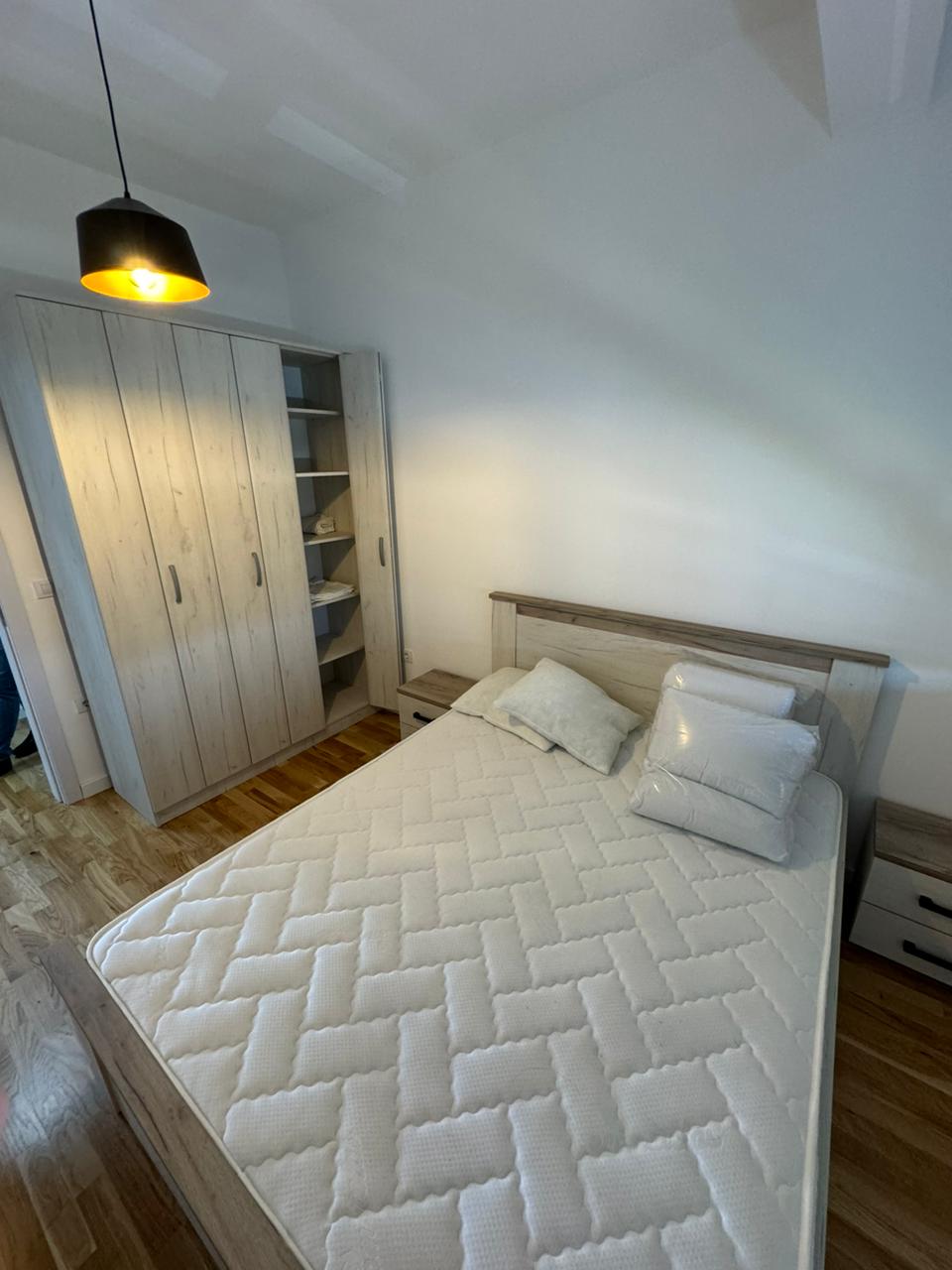 Spacious Ulcinj bedroom with modern double bed, ample wardrobe, and elegant wooden floors&mdash;exclusive listing by ekosphere doo.