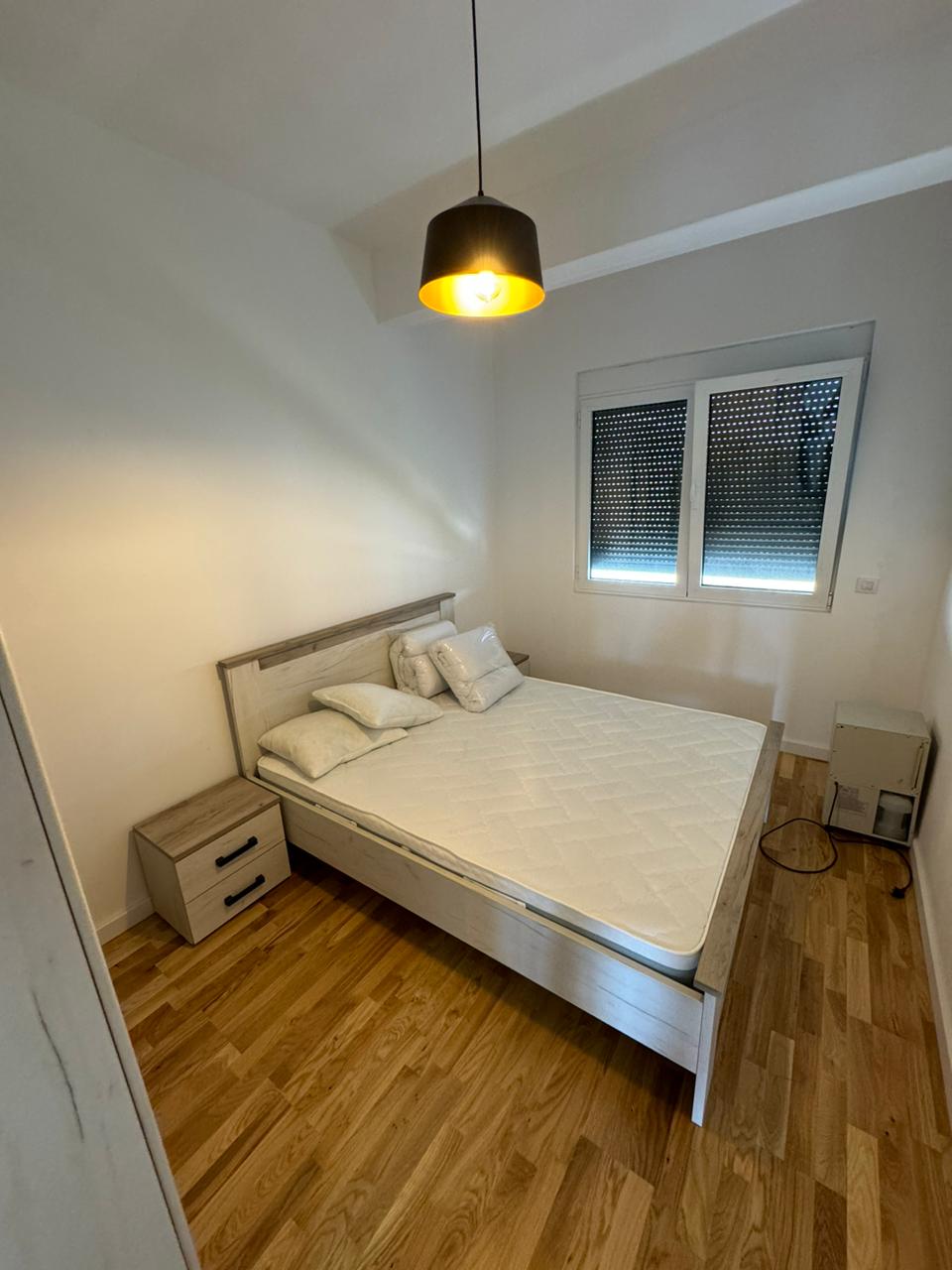 Modern Ulcinj bedroom featuring a double bed, elegant wood floors, and ample natural light&mdash;ideal Montenegro real estate investment.