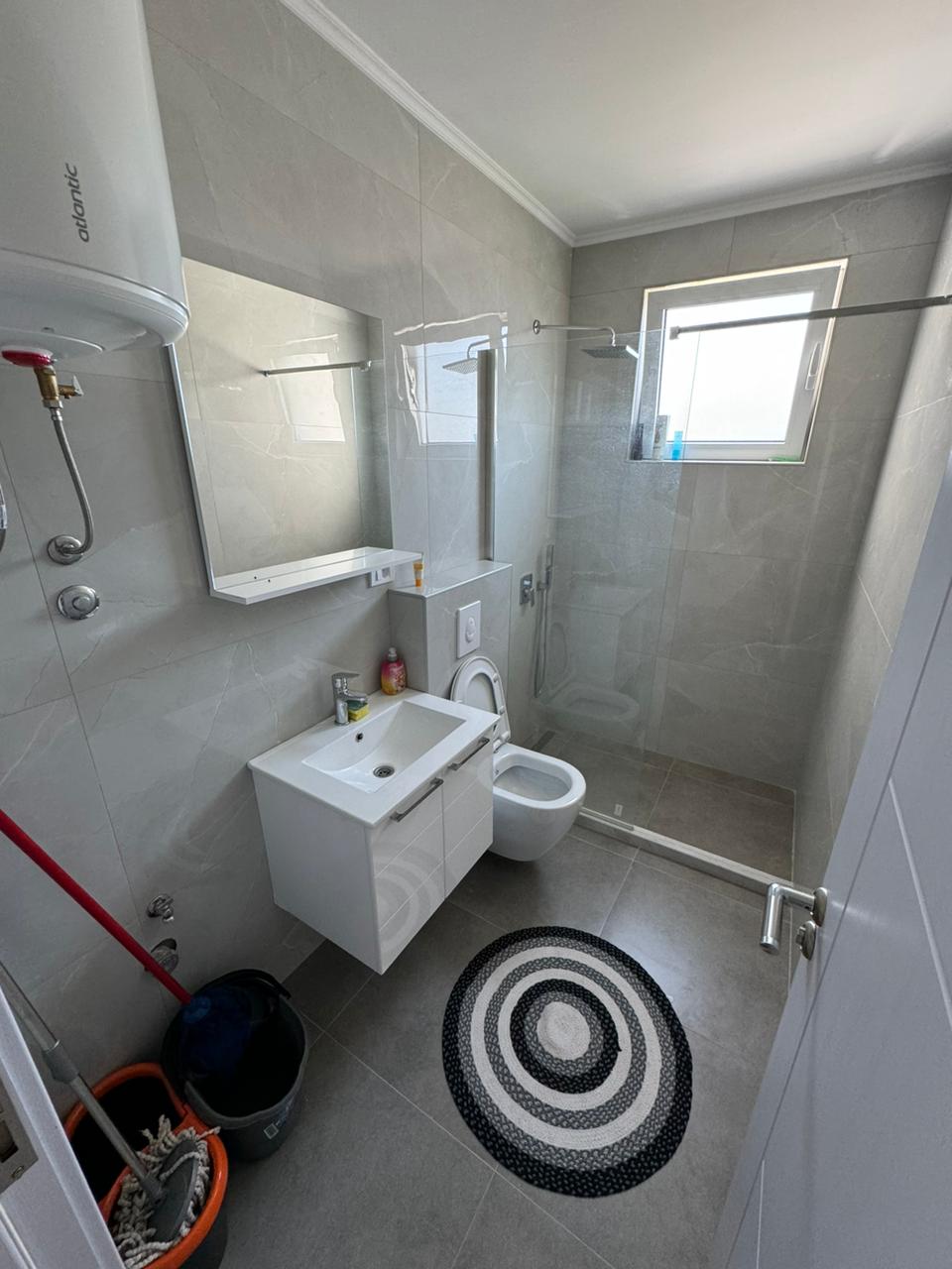 Elegant modern bathroom in Ulcinj, Montenegro: gray tiles, glass-door shower, quality fixtures&mdash;exclusive with montenegro-listings.me by ekosphere doo.