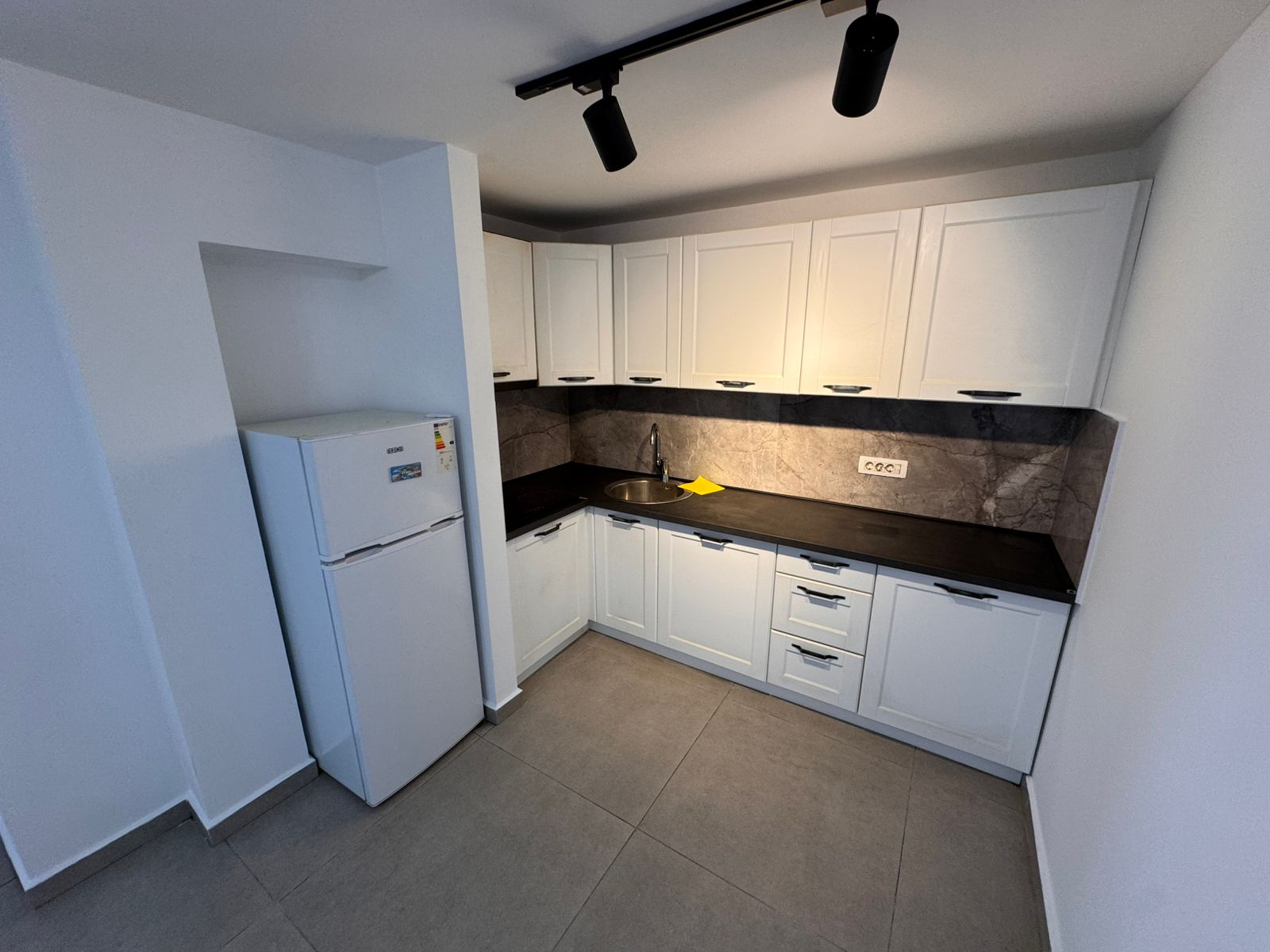 Stunning Ulcinj kitchen: sleek white cabinets, gray counters, stainless sink&mdash;an ideal Montenegro investment. By ekosphere doo.