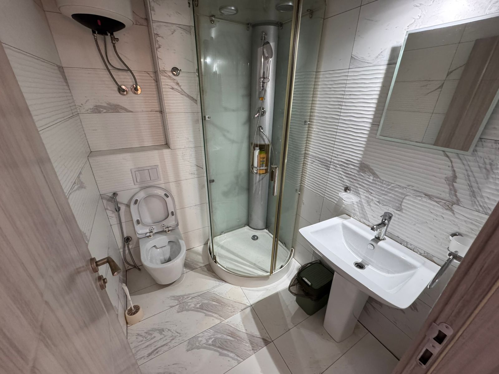 Contemporary bathroom with elegant white marble tiles, glass shower, modern fixtures&mdash;prime Ulcinj real estate by montenegro-listings.me.