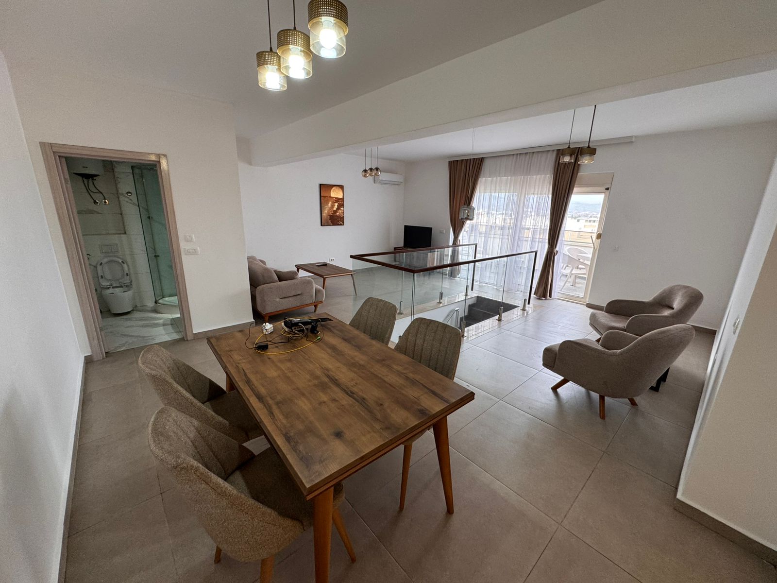 Spacious open-plan living/dining in Ulcinj with modern furnishings, large windows, and bathroom&mdash;exclusive at montenegro-listings.me.