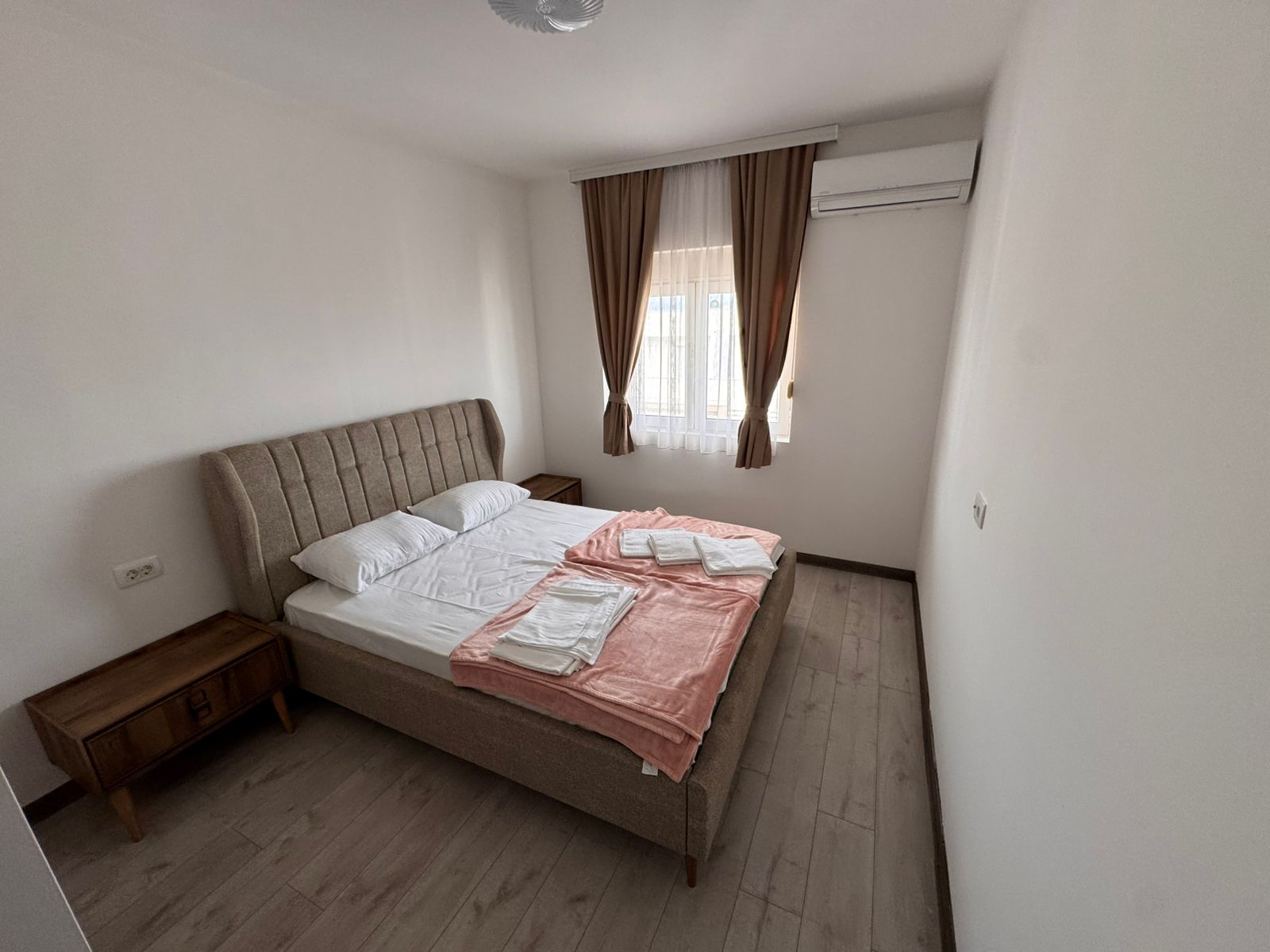 Modern Ulcinj bedroom: double bed, nightstands, AC, and wood floors&mdash;ideal Montenegro investment on montenegro-listings.me by ekosphere doo.