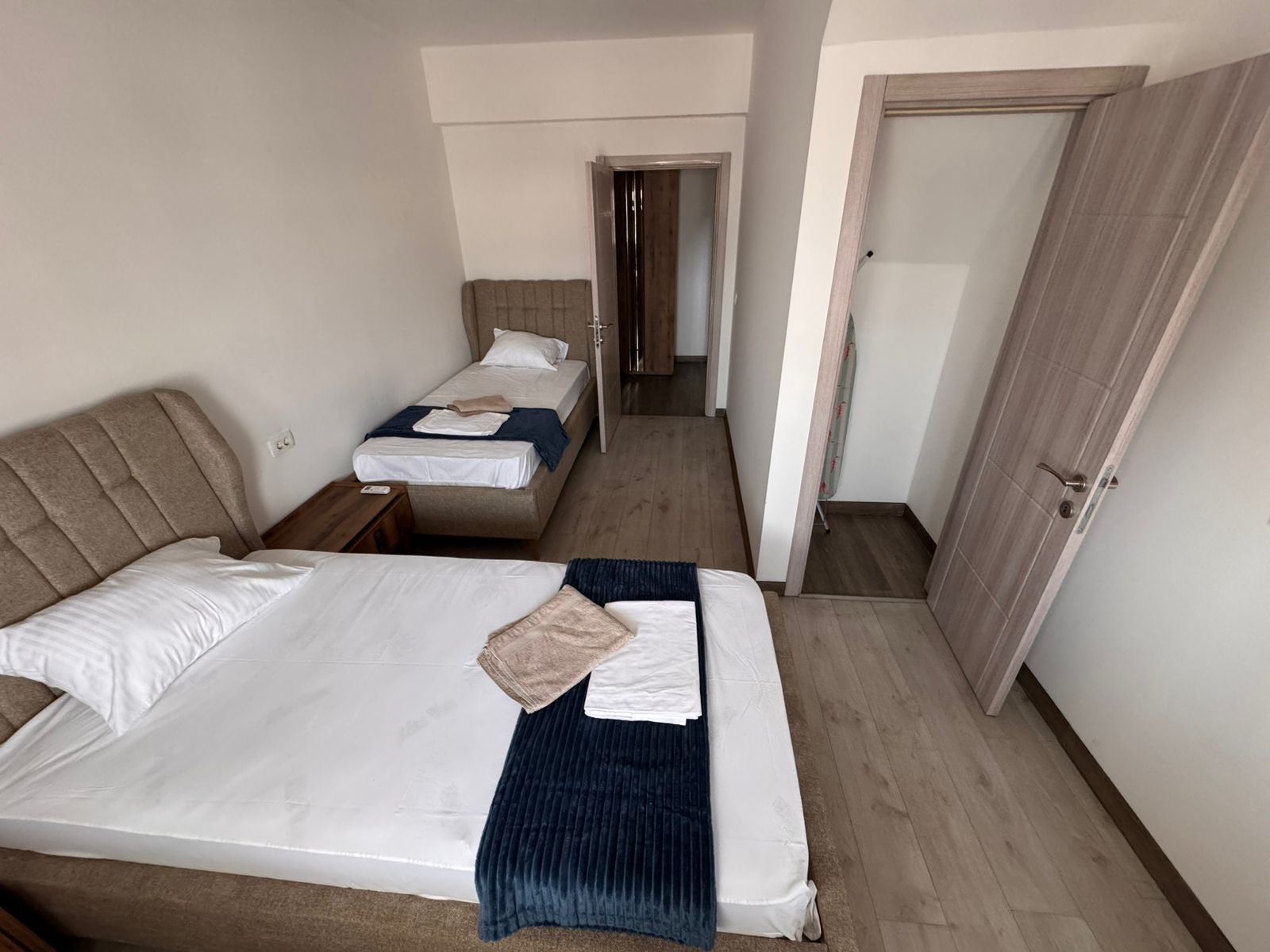 Modern Ulcinj hotel room with twin beds, navy accents, premium linens, storage space; prime Montenegro investment at montenegro-listings.me by ekosphere doo.