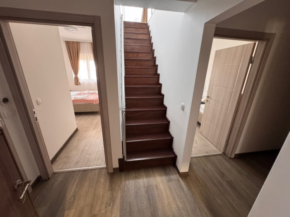 Elegant wooden staircase connects two sunlit bedrooms with stylish wood floors in a prime Ulcinj property&mdash;exclusively at montenegro-listings.me by Ekosphere doo.